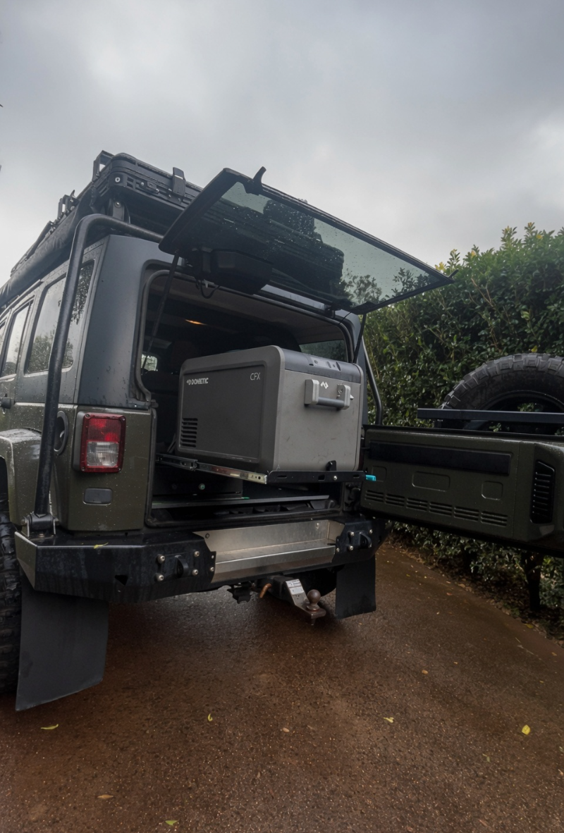 Jeep JK Unlimited fridge slide side view — Dometic CFX5 45 on heavy-duty slide mount, 12V touring install by TAWL